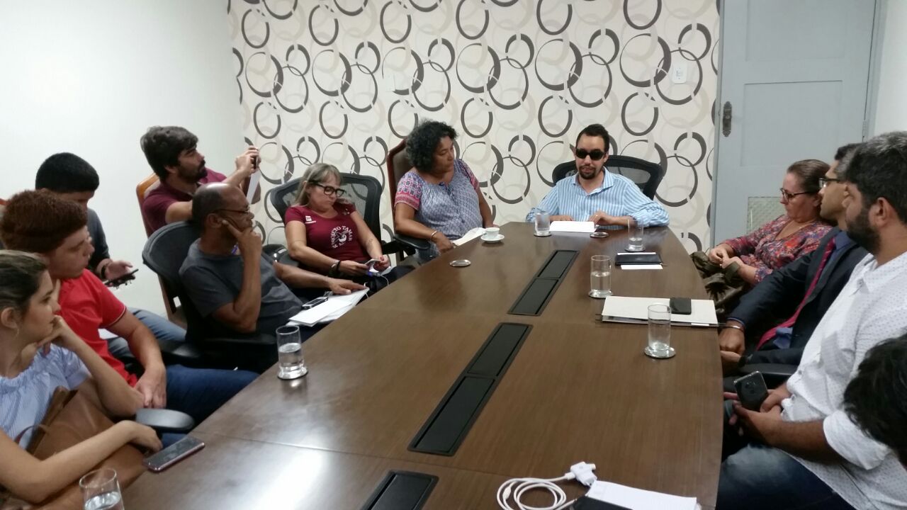 Vereador Lucas Aribé sentado à mesa com produtores culturais e membros de entidades representativas das pessoas com deficiência