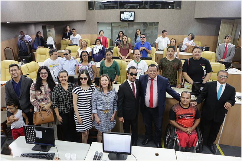 O vereador Lucas Aribé está posando para uma foto juntamente com os participantes da mesa e o público presente