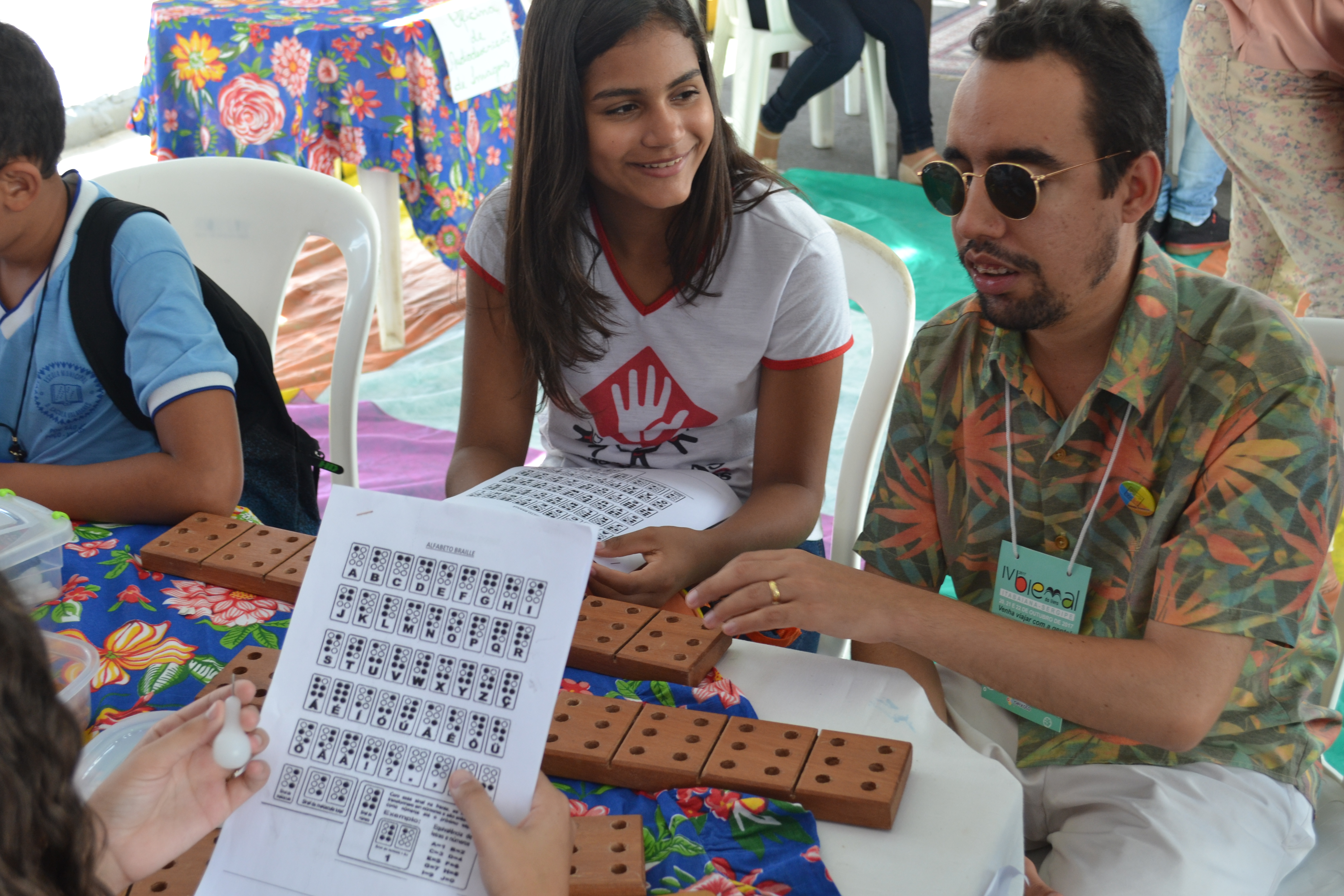 #PraCegoVer: Natalia Emanuele, 12 anos, do povoado de São José, ao lado de Lucas Aribé, acompanha oficina de Braille