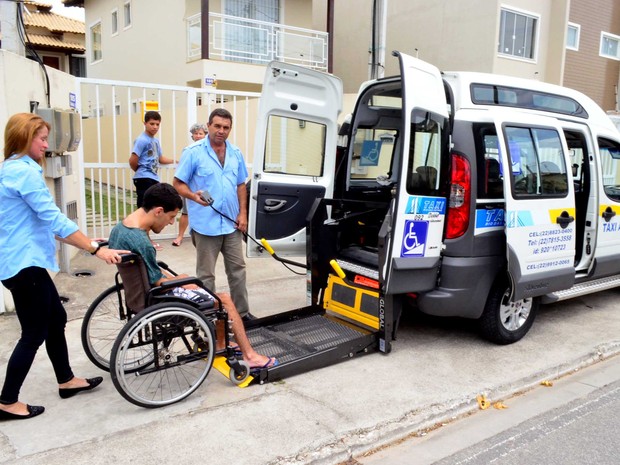 Táxi adaptado em Rio das Ostras já é realidade (Crédito: Gabriel Sales) #PraCegoVer: cadeirante está entrando em um carro tipo doblô em uma rampa que é acionada com a ajuda do taxista