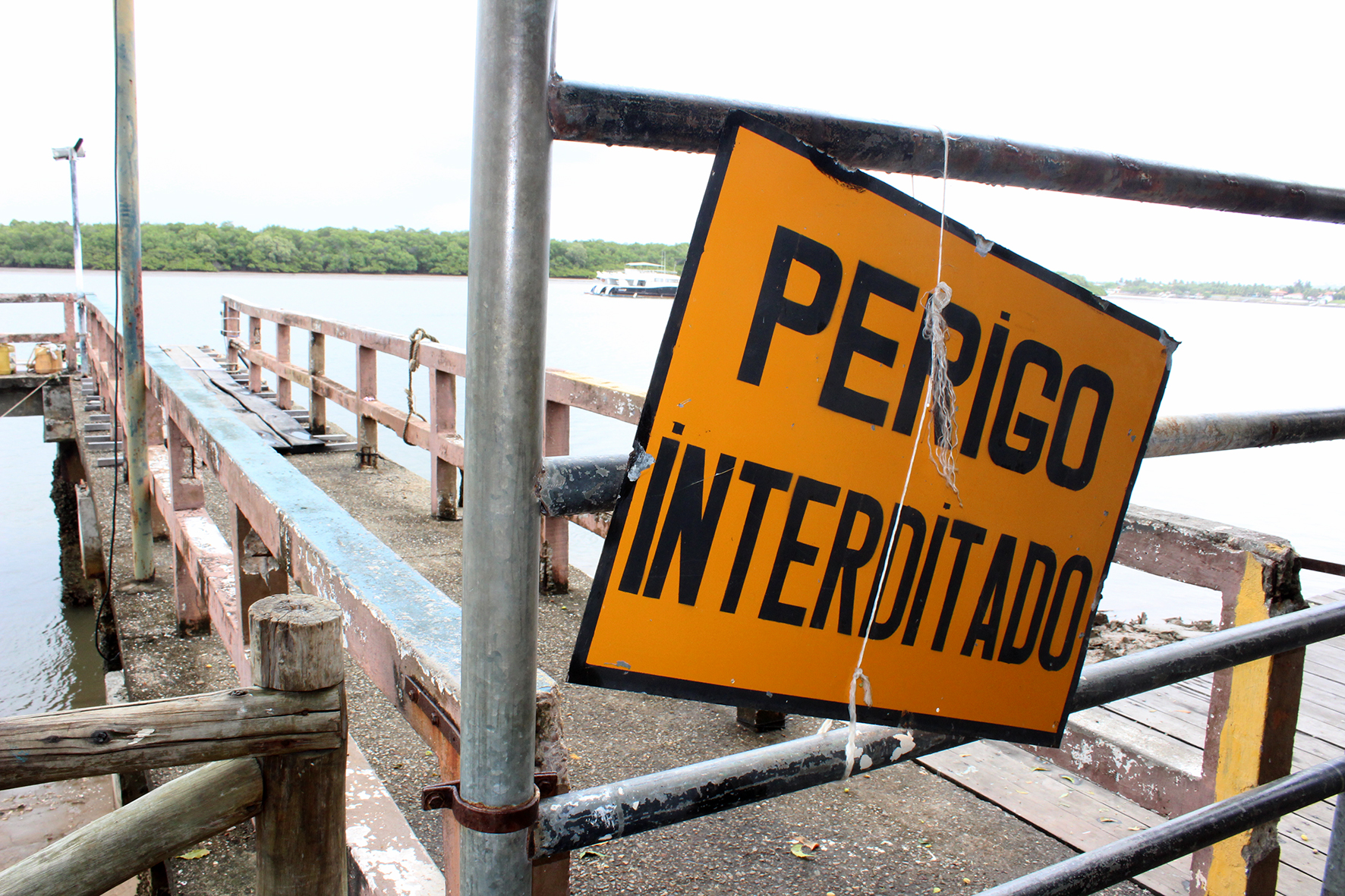 #PraCegoVer - Placa alerta sobre perigos no cais interditado