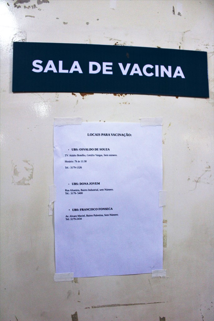 #PraCegoVer - Na porta da sala de vacinação, cartaz orienta cidadãos a procurarem outros postos