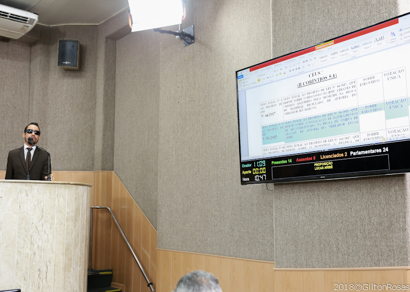 #PraCegoVer - No canto esquerdo da foto, Lucas defende projeto de lei na tribuna. No canto direito, o telão exibe informações sobre o veto ao projeto de lei