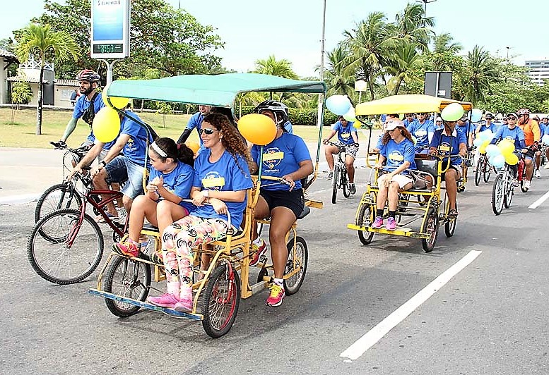 #PraCegoVer - Imagem de passeio ciclístico anterior, com pessoas pedalando em triciclos e quadriciclos