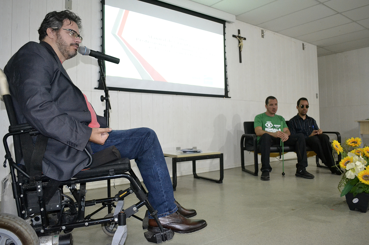 #PraCegoVer - Guilherme Pereira ministra palestra. Também no palco, Railton Correia e Lucas Aribé