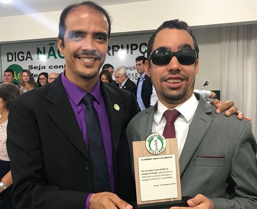 #PraCegoVer: O vereador Lucas Aribé está sorrindo com o troféu na mão