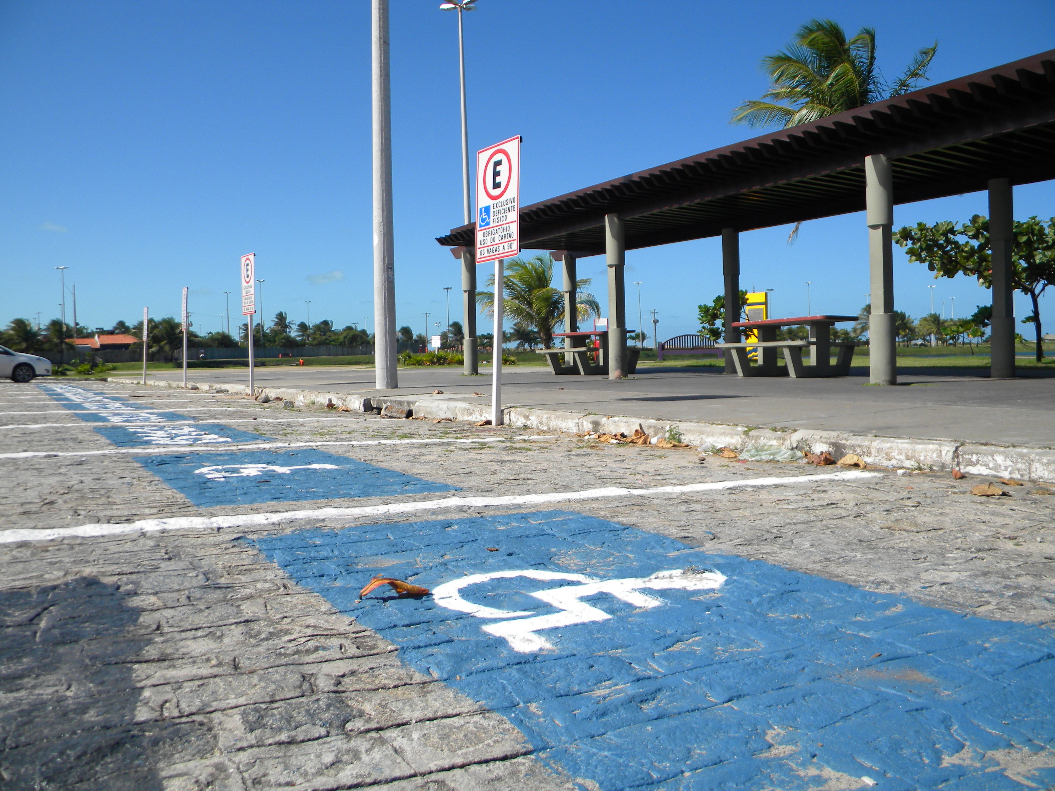 Imagem do estacionamento da Orla. Na foto, o chão demarcado com o símbolo universal da pessoa com deficiência
