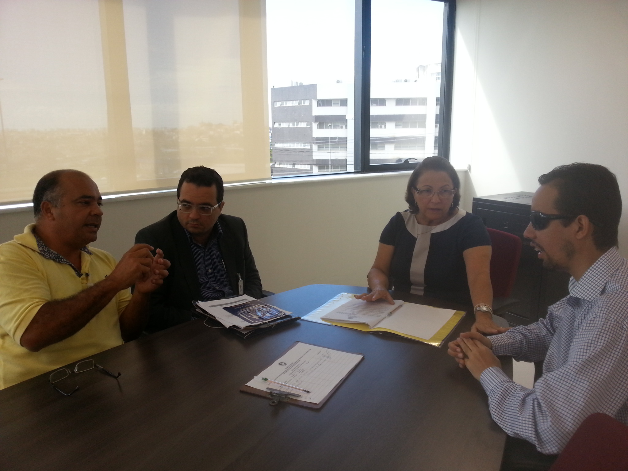 Na imagem, os presentes na audiência estão sentados em frente a uma mesa. Da esquerda para a direita: o diretor da Ases, Roberto Orrico, o advogado Thiago Cabral, a promotora Berenice Melo e o vereado