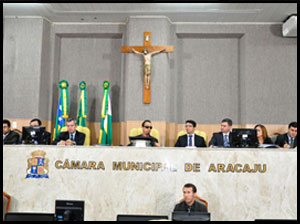 Componentes da mesa sentados de frente para o plenário.